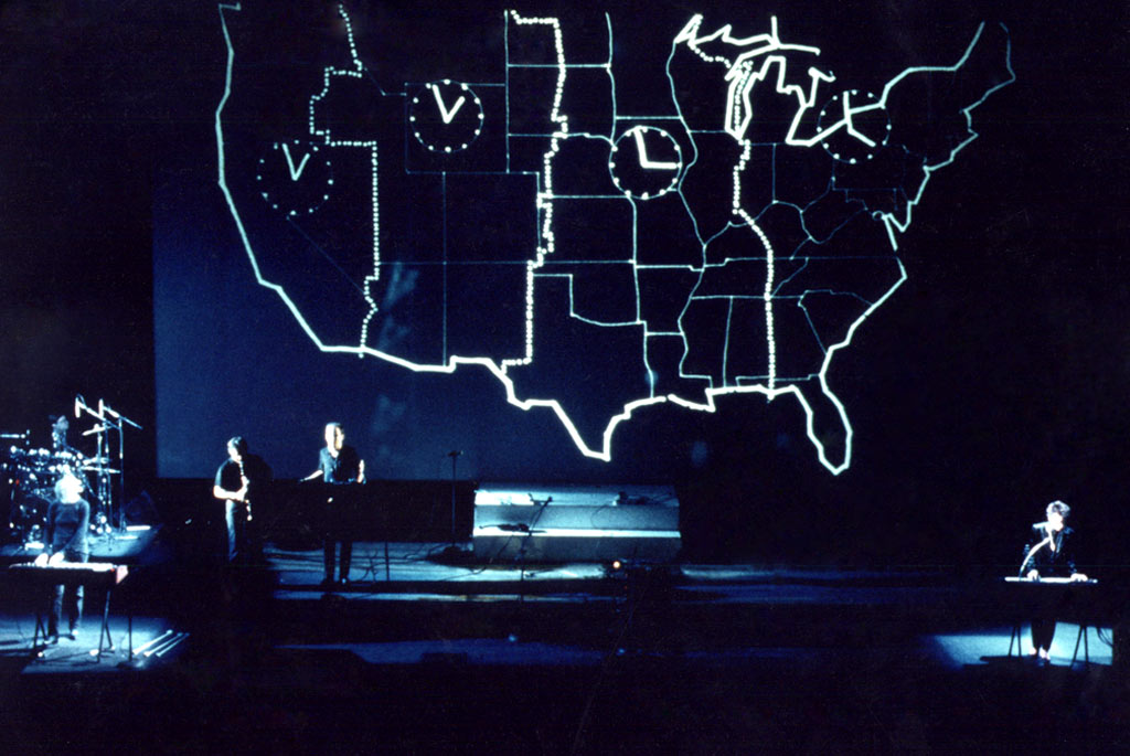 laurie anderson w/band on stage in front of map of the USA